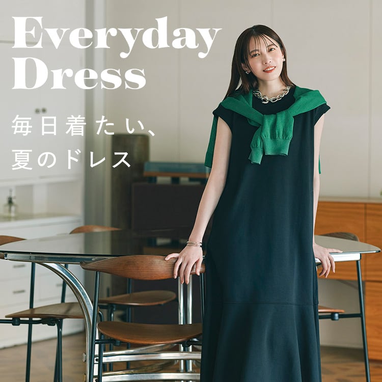 女性身着黑色连衣裙站在现代室内空间